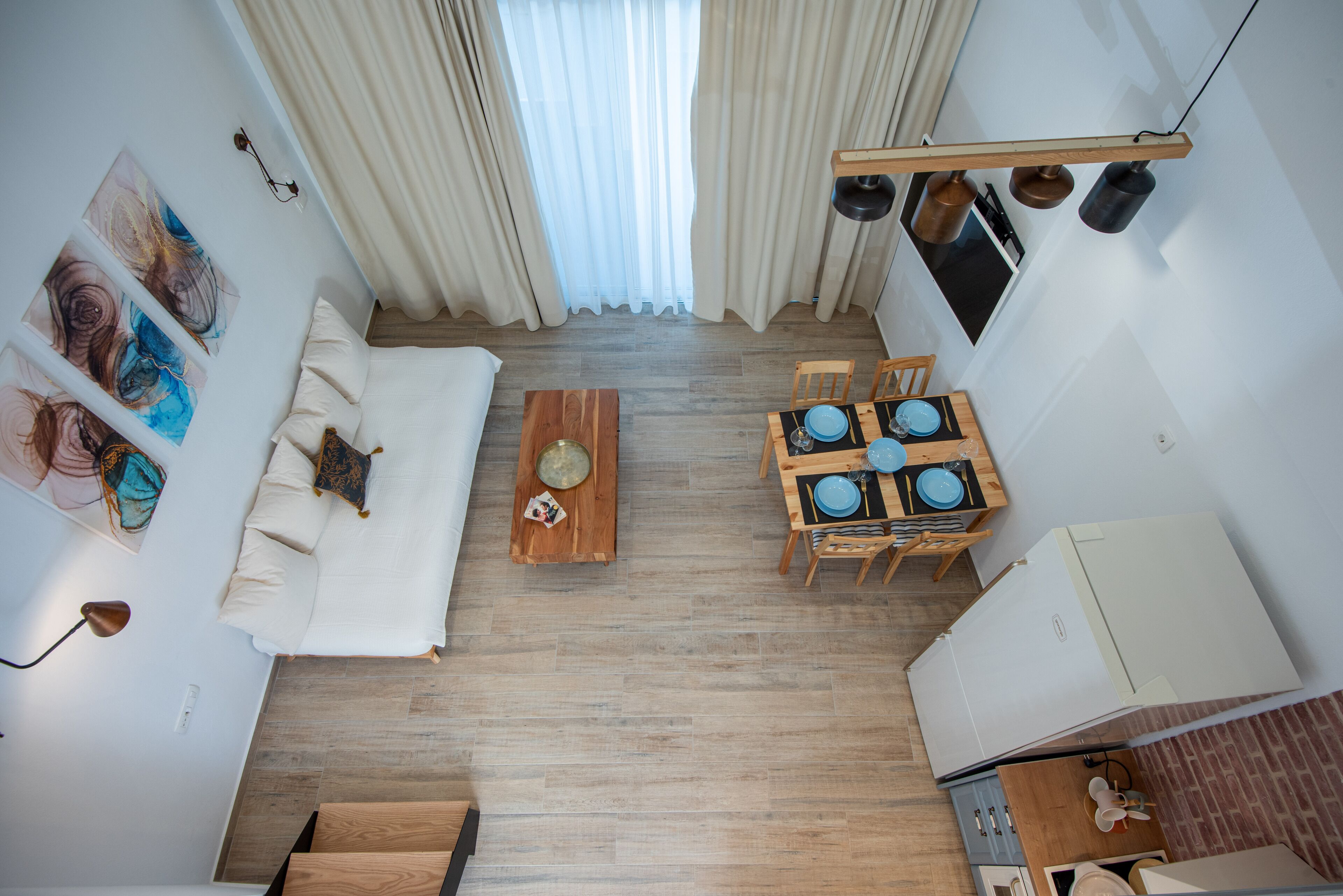 Un salon moderne avec un canapé, une table basse en bois et un coin repas comprenant des chaises et de l’assiette.