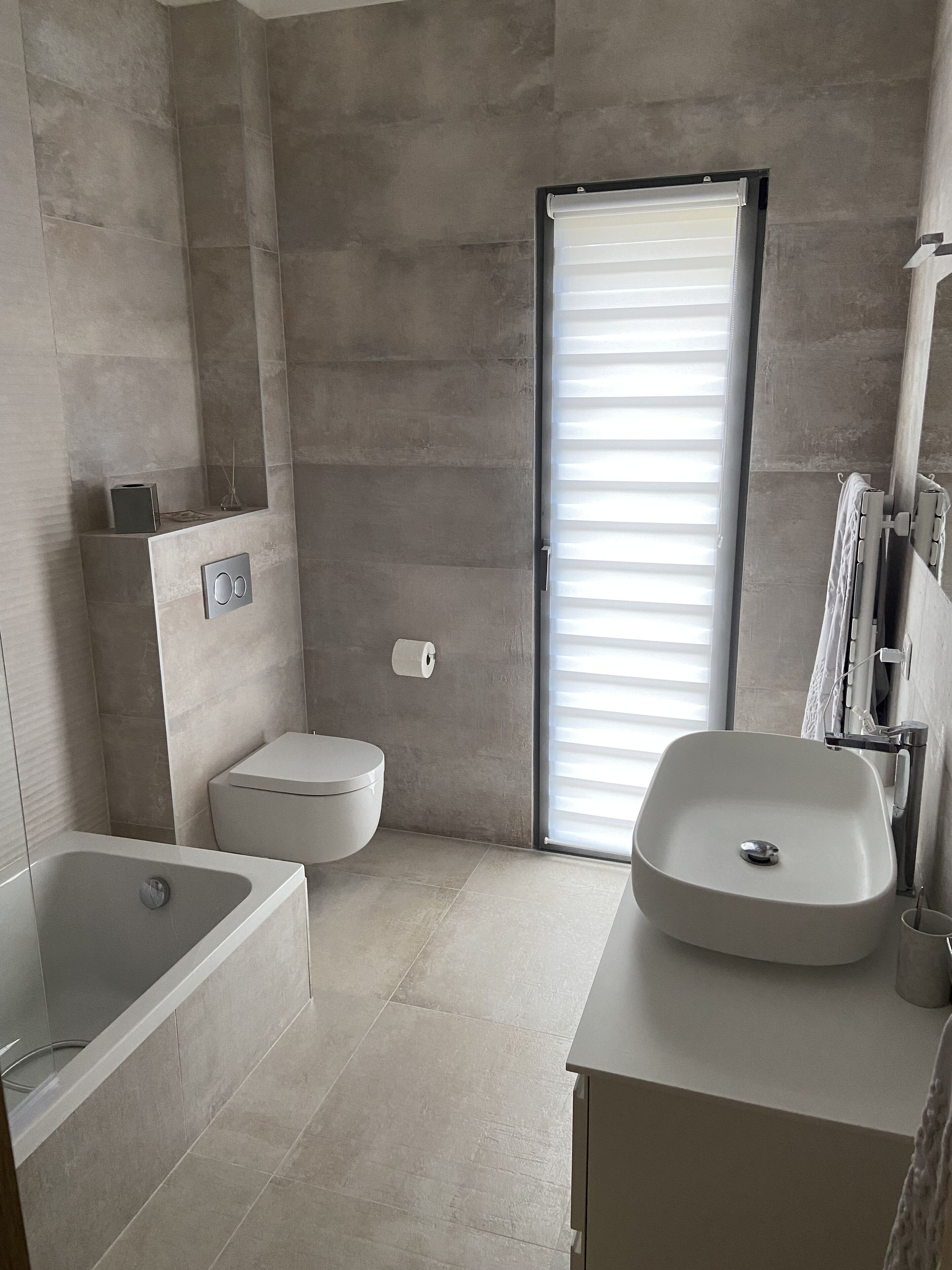 A modern bathroom with a bathtub, toilet, and sink.