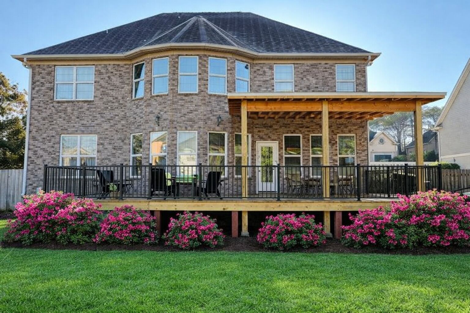 A two-story house with a covered patio and a brick exterior.