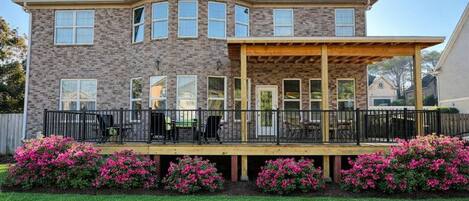 A two-story house with a covered patio and a brick exterior.