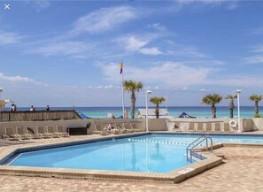 Relax by the ocean-view pool surrounded by lounge chairs and umbrellas.
