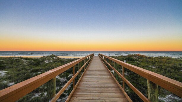 A wooden boardwalk leading to the beach with a clear view of the ocean and sky. - Pelican Inlet - Cozy Beach Condo!1 block from the beach! Sleeps 6. Pool/Tennis (St. Augustine)
