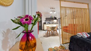 Una habitación de hotel moderna con comedor, cocina y puerta corrediza.