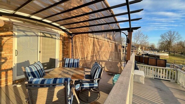 A covered patio with a wooden deck, outdoor seating, and a view of a residential neighborhood. - POOL house with FENCED Yard for Pets, by the ARK Encounter, Airport, Cincinnati (Independence)