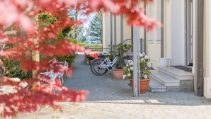 Un camino pavimentado que conduce a la entrada de un edificio, con una bicicleta estacionada afuera.
