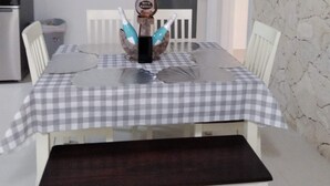 A dining area with a checkered tablecloth, white chairs, a chandelier, and a marble wall. - Viamarhe-3/1 Ground Level Oceanfront home w/Kayaks, Yard Games & More (Marathon)