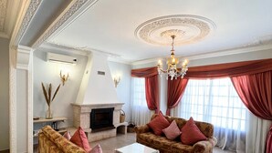 A spacious living room with floral-patterned sofas, a fireplace, and a chandelier. - Sunshine Villa (Faro)