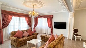 A spacious living room with floral-patterned sofas, a white coffee table, and a chandelier. - Sunshine Villa (Faro)