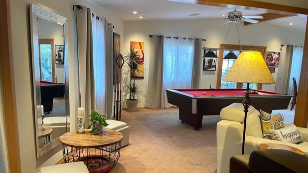 A living room with a pool table, a round coffee table, and a sofa. - Cheerful Single Story 3-bedroom home w pool table (Santa Clarita)