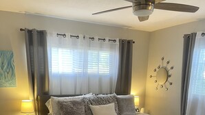 A bedroom with a bed, bedside tables, a ceiling fan, and a wall clock. - Cheerful Single Story 3-bedroom home w pool table (Santa Clarita)