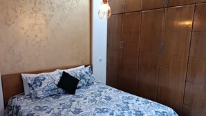 A bedroom with a bed, a wardrobe, and a hanging light fixture. - Luxury Family House with Garden View Casablanca (Dar-el-Beida)