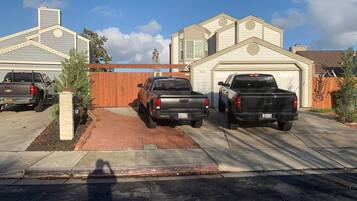 Un camino de acceso residencial con tres camionetas estacionadas.