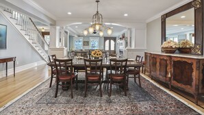 A dining area with a chandelier, wooden dining table, and chairs. - Four Oceanview Balconies overlooking the beach!  (Neptune Township)