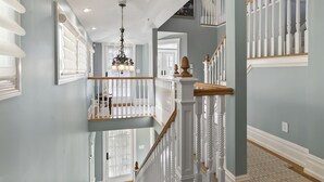 A multi-level interior with a staircase, white railings, and a chandelier. - Four Oceanview Balconies overlooking the beach!  (Neptune Township)
