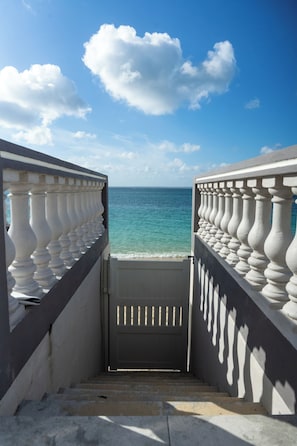 Une vue à travers une porte ornée de balustrades, qui donne sur une étendue d’eau.