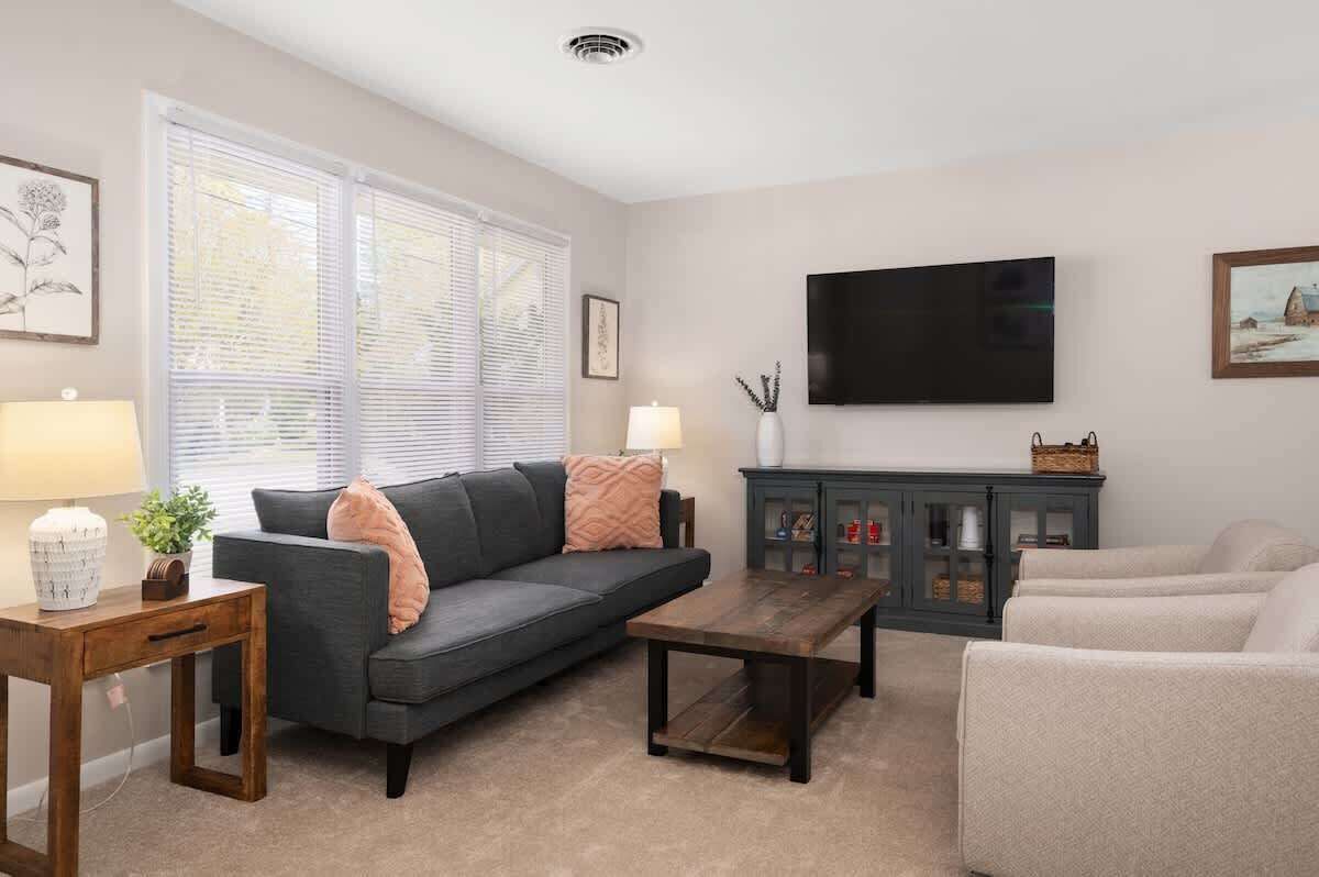 A living room with a sofa, coffee table, TV, and a cabinet.
