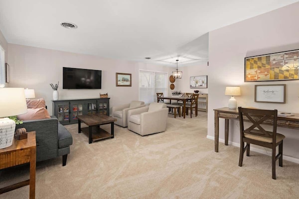 Bright and spacious living room featuring ample seating, a smart TV for entertainment with Netflix, and a dedicated desk for work or study. A perfect blend of comfort and functionality!