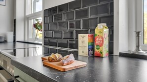 Un plan de travail de cuisine avec une planche à découper, un emballage de jus de pomme Ebel Most et une boîte de café Equality.