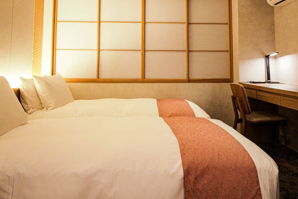 Een hotelkamer met een groot bed, een bureau en een stoel.
