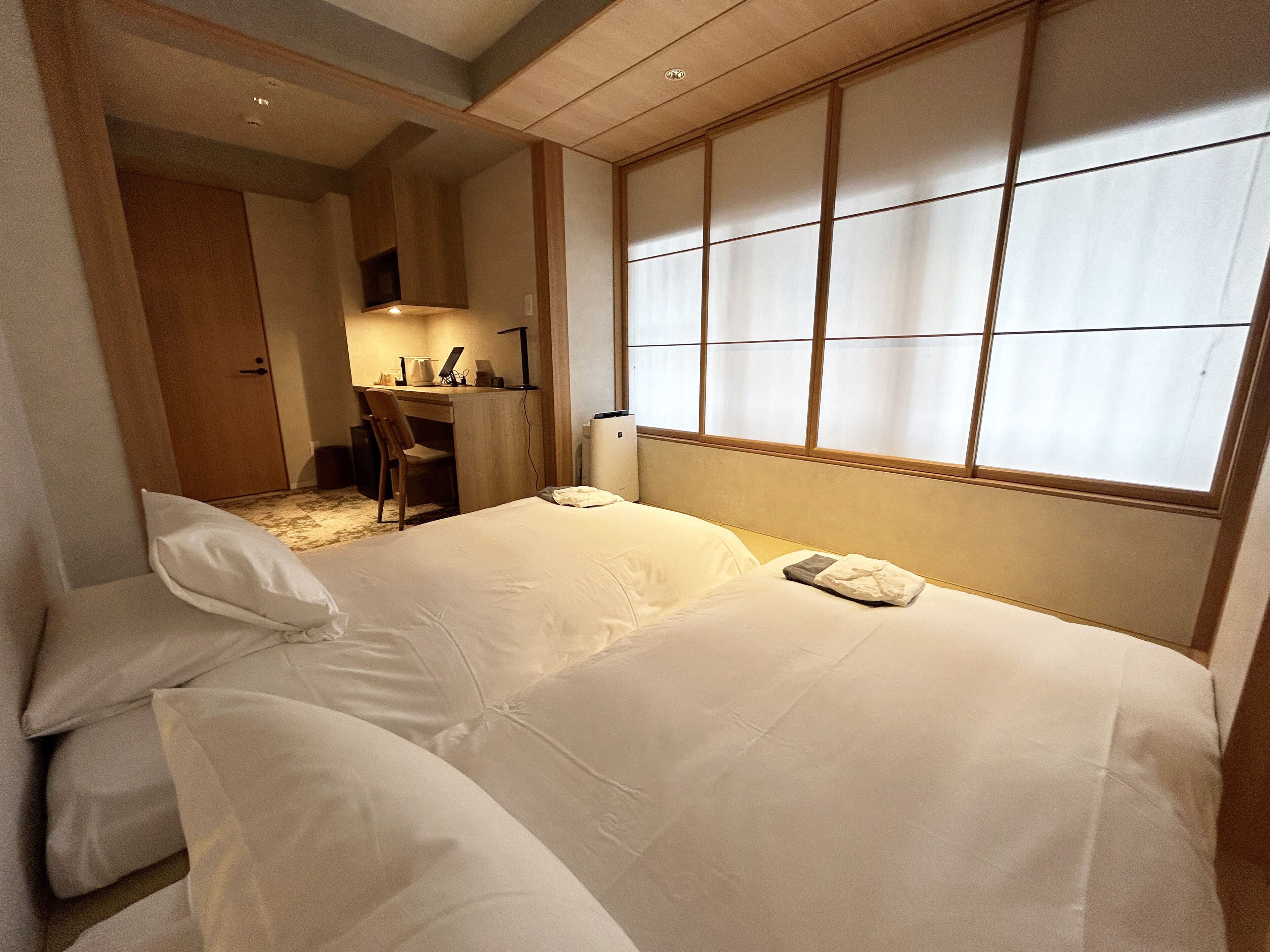 Une chambre d’hôtel avec un lit, un bureau et une chaise.