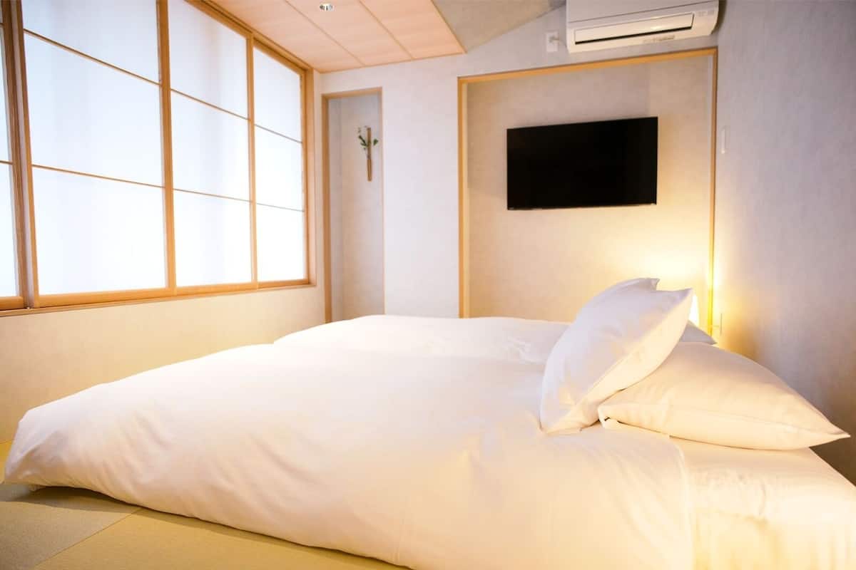 Hotelkamer met een groot bed, een tv aan de muur en een raam met uitzicht.