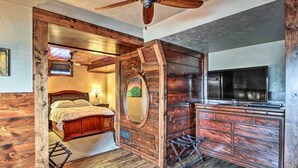 A rustic room with a wooden ceiling, a bed, a dresser, and a television. - Peace & Quiet on Alpaca Farm! Paola Studio (Paola)