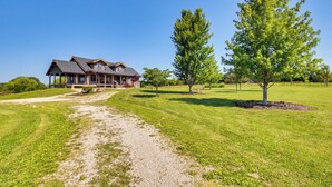 A large, two-story house with a covered porch and a gravel driveway leading to it. - Peace & Quiet on Alpaca Farm! Paola Studio (Paola)