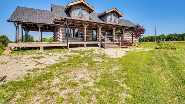 A large, two-story log cabin with a covered porch and a landscaped yard. - Peace & Quiet on Alpaca Farm! Paola Studio (Paola)