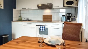 A compact kitchen with white cabinets, a microwave, a toaster, and a coffee maker. - Lake front home in Heidesee with WiFi (Heidesee)