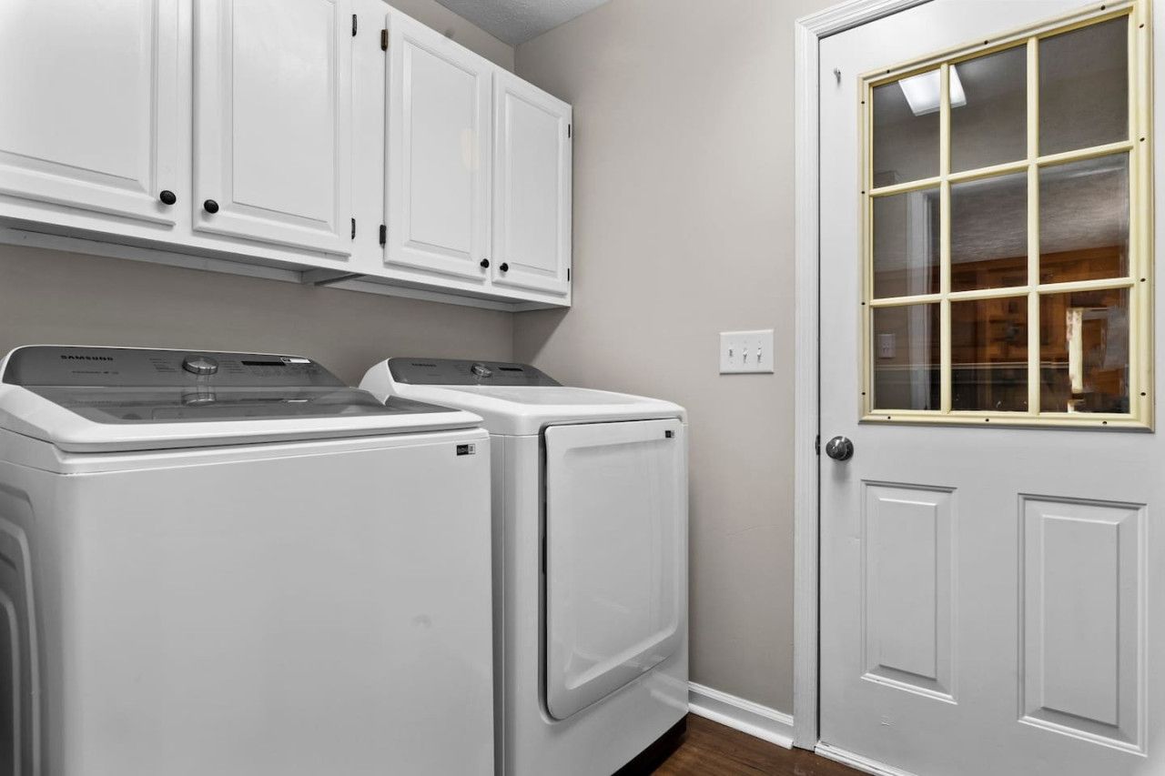 A laundry area with two front-loading washers and a cabinet above.