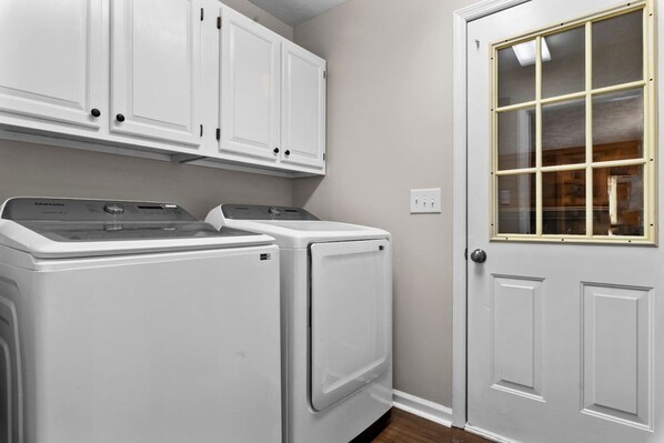 A laundry area with two front-loading washers and a cabinet above.