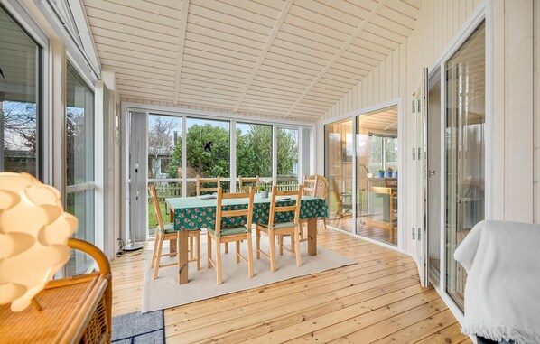 Enjoy a meal or relax in this room with a sliding glass door leading to an outdoor area, a wooden table, and six chairs.