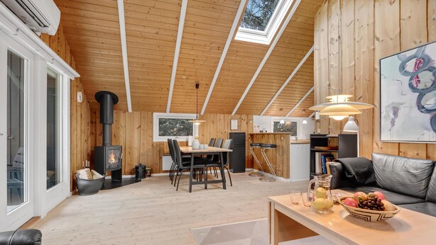 A cozy cabin interior with a dining area, a sofa, and a fireplace. - Awesome home in Oksbøl with WiFi (Oksbøl)