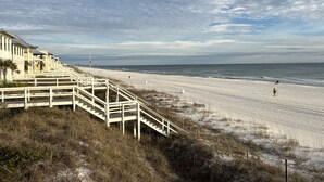 A beach with a wooden staircase leading down to the shore, a sandy beach, and the ocean in the background. - Newly Remodeled. 20 second walk to Beach walkover. Gulf views on 2nd/3rd floors! (Panama City Beach)