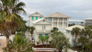 A multi-story building with balconies and a white picket fence. - Newly Remodeled. 20 second walk to Beach walkover. Gulf views on 2nd/3rd floors! (Panama City Beach)