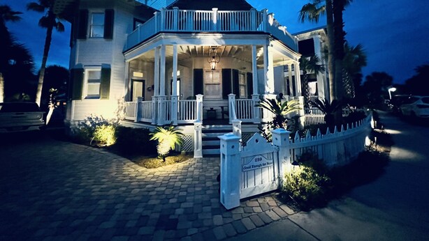 A two-story house with a porch, a driveway, and a gated entrance. - Newly Remodeled. 20 second walk to Beach walkover. Gulf views on 2nd/3rd floors! (Panama City Beach)