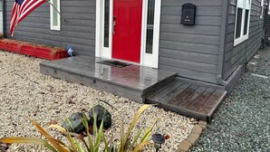 Ein Haus mit roter Tür, einem Briefkasten und einer amerikanischen Flagge.