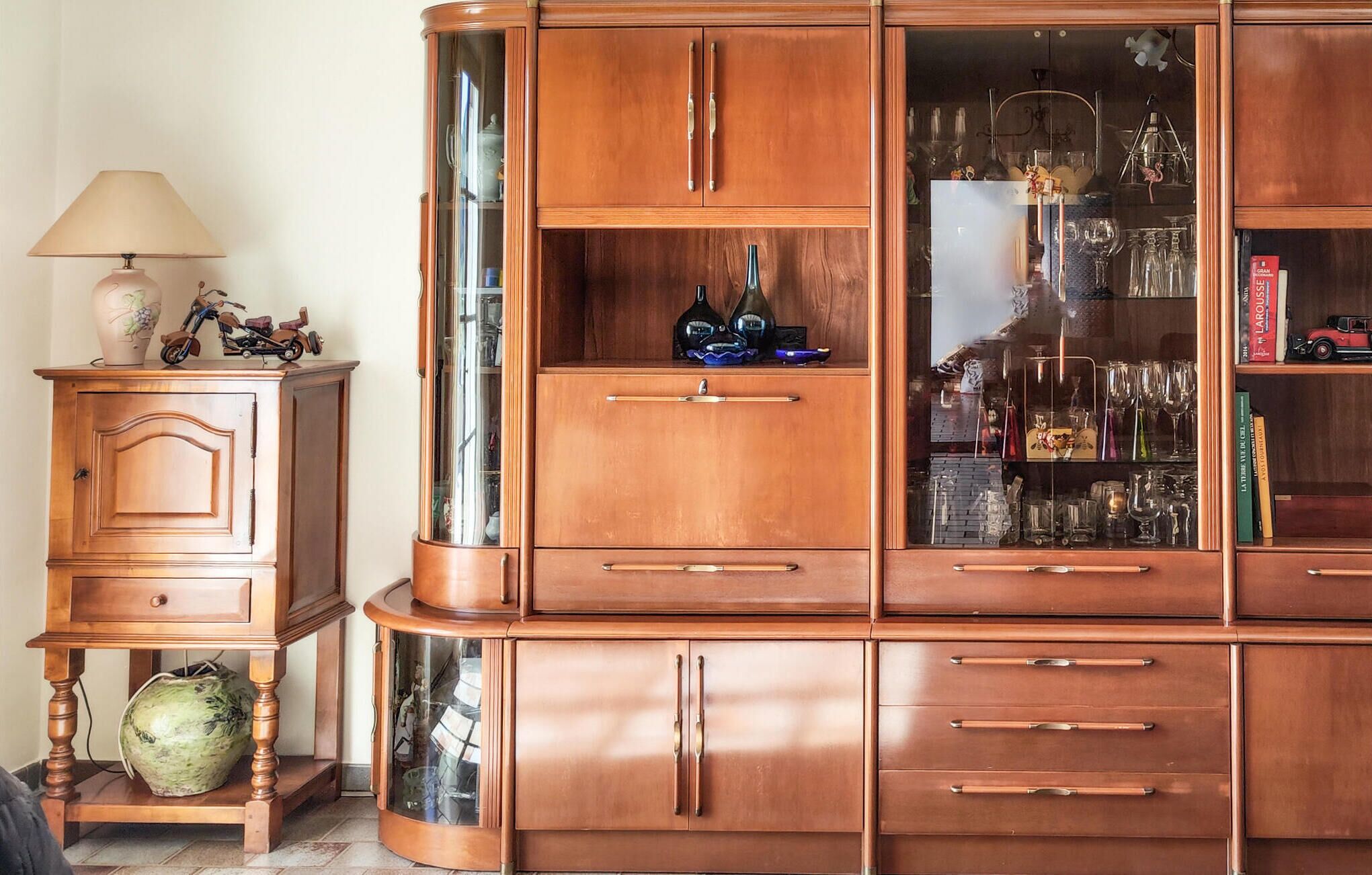 Un mueble de madera con varios cajones y puertas de cristal, presumiblemente usado para guardar objetos.
