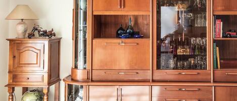 Un mueble de madera con varios cajones y puertas de cristal, presumiblemente usado para guardar objetos.