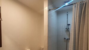 Un baño con ducha, inodoro y lavabo.