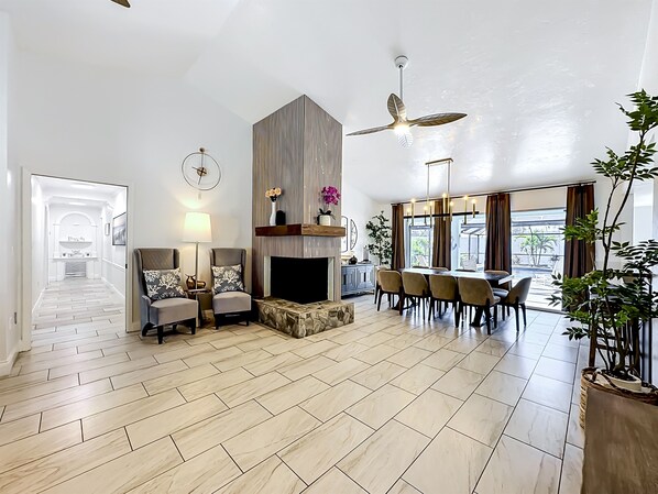 A spacious living area with a fireplace, seating, and a dining table.