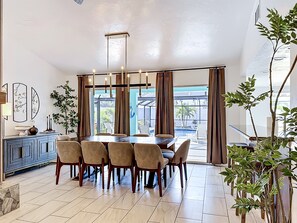 A dining area with a table, chairs, and a view of the outdoors.