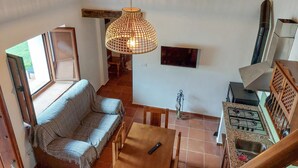 A cozy living area with a sofa, a wooden table, and a hanging light fixture.