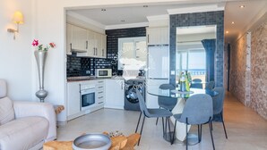 A modern kitchen with white cabinets, a microwave, and a washing machine. - CostaBlancaDreams - Capri in Calpe (Calpe)