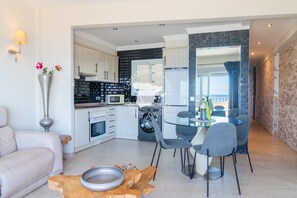 A modern kitchen with white cabinets, a microwave, and a washing machine. - CostaBlancaDreams - Capri in Calpe (Calpe)