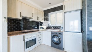 A modern kitchen with a washing machine, oven, and a refrigerator. - CostaBlancaDreams - Capri in Calpe (Calpe)