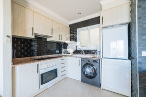 A modern kitchen with a washing machine, oven, and a refrigerator. - CostaBlancaDreams - Capri in Calpe (Calpe)