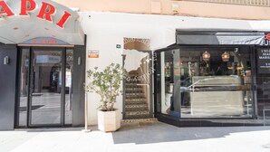 A storefront with a sign that reads 'R. CAPRI' and another sign for 'CocaColaDreams.' There is a potted plant in front of the entrance. - CostaBlancaDreams - Capri in Calpe (Calpe)