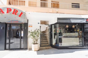 A storefront with a sign that reads 'R. CAPRI' and another sign for 'CocaColaDreams.' There is a potted plant in front of the entrance. - CostaBlancaDreams - Capri in Calpe (Calpe)