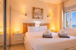 A hotel room with a bed, two bedside tables, a wall-mounted radiator, and a window with curtains. - CostaBlancaDreams - Capri in Calpe (Calpe)